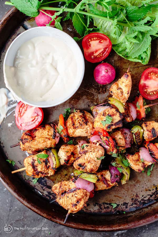 Mediterranean Grilled Chicken Kabobs Recipe + Cayenne Tahini Sauce! Make chicken kabobs like a Mediterranean pro! Marinated in Mediterranean spices with fresh garlic and lime juice, these kabobs are simply succulent! Try them for your next party with an easy tahini sauce!