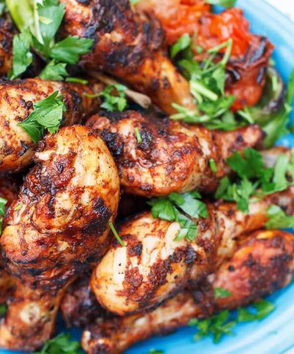 Grilled Chicken Drumsticks Recipe with Garlic Harissa Marinade | The Mediterranean Dish. This Moroccan-inspired chicken recipe will be your new go-to! Chicken drumsticks marinated in a spicy and zesty sauce of garlic, harissa paste, and Mediterranean spices with lime juice and olive oil. The result, succulent, flavor-packed grilled chicken that will please everyone! Get the easy step-by-step today!