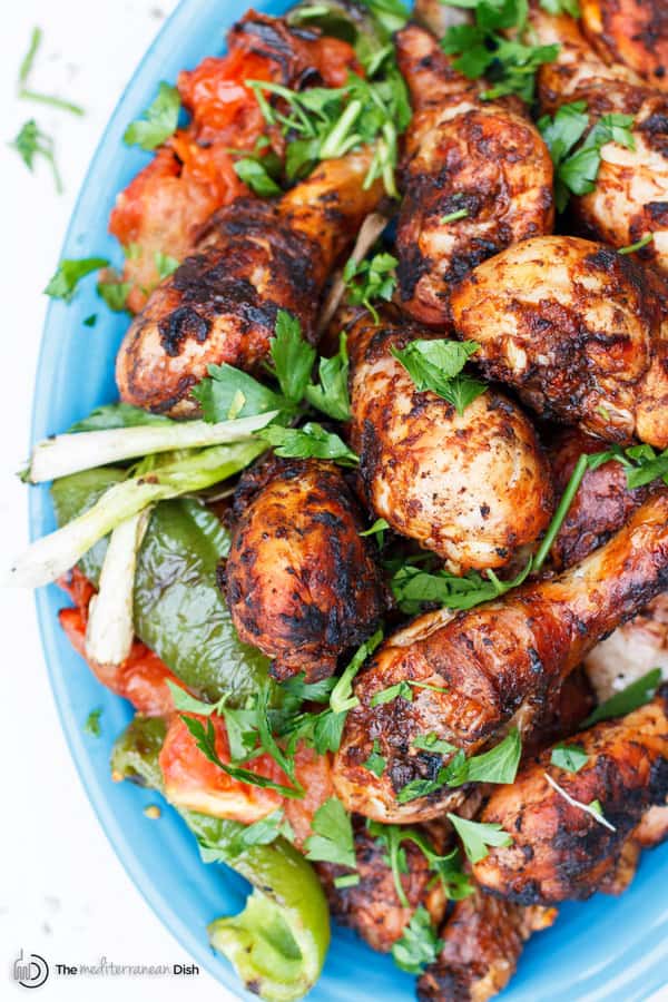 Grilled Chicken Drumsticks Recipe with Garlic Harissa Marinade | The Mediterranean Dish. This Moroccan-inspired chicken recipe will be your new go-to! Chicken drumsticks marinated in a spicy and zesty sauce of garlic, harissa paste, and Mediterranean spices with lime juice and olive oil. The result, succulent, flavor-packed grilled chicken that will please everyone! Get the easy step-by-step today!