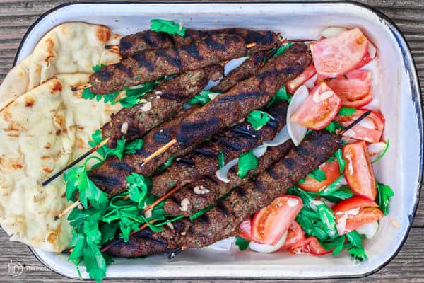 Grilled Kebabs with a side of pita bread, garnished with fresh parsley