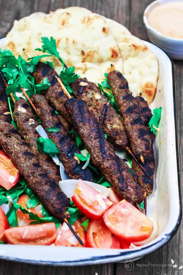 Kofta Kebabs served on a platter with tomato wedges and pita bread