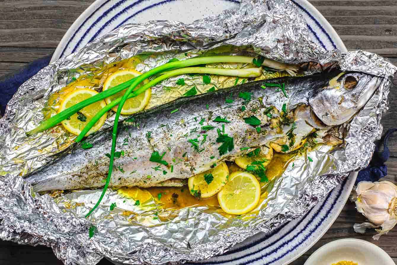 Mediterranean Oven Baked Spanish Mackerel Recipe | The Mediterranean Dish. Easy Greek inspired recipe. Whole fish stuffed with garlic, herbs, and lemon slices and oven baked in a foil packet with olive oil. A delicious Mediterranean diet recipe. See it on TheMediterraneanDish.com