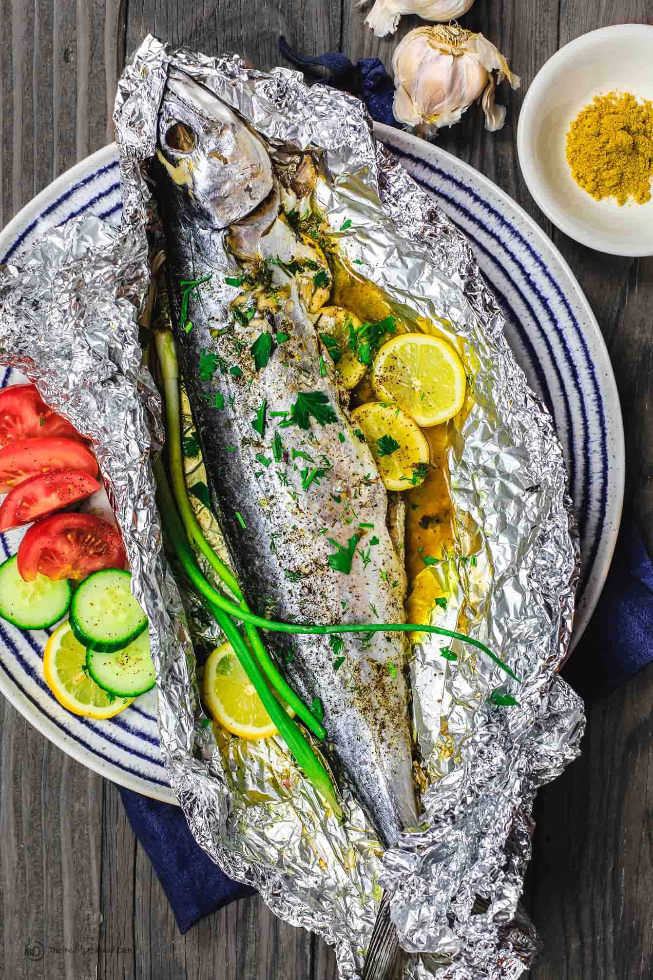 Mediterranean Oven Baked Spanish Mackerel Recipe | The Mediterranean Dish. Easy Greek inspired recipe. Whole fish stuffed with garlic, herbs, and lemon slices and oven baked in a foil packet with olive oil. A delicious Mediterranean diet recipe. See it on TheMediterraneanDish.com