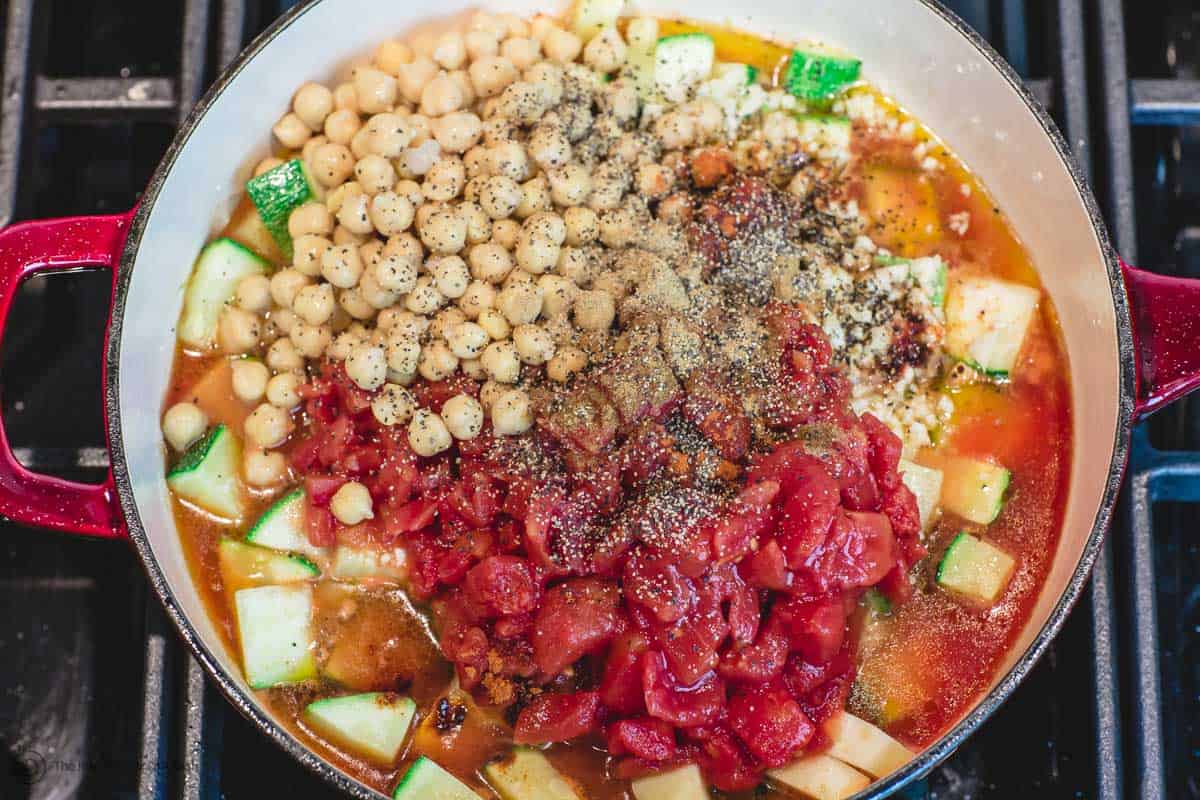 Garlic, chickpeas, tomatoes and spices are added to skillet