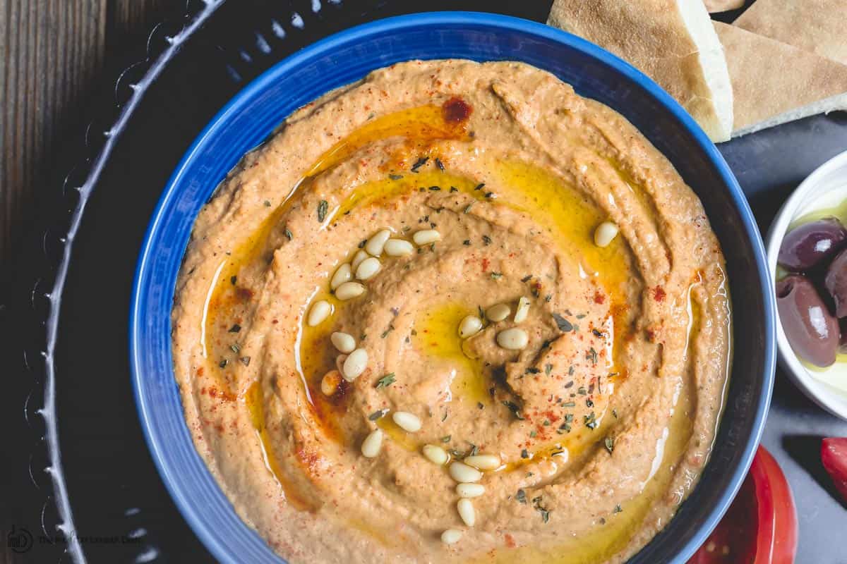 Roasted red pepper hummus with a side of pita and veggies to dip