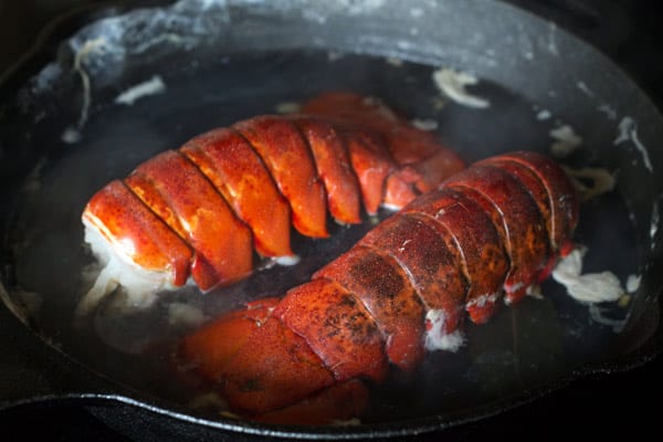 Lobster tail being cooked in a pan
