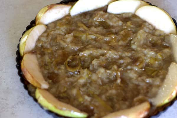 Slices of pears placed in a ring around top of puree-covered pie crust