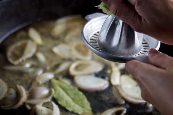 Fresh lemon juice added to skillet with vegetables