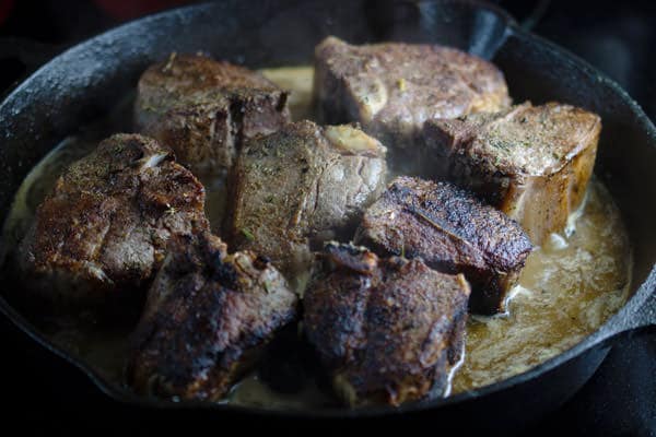 Spiced lamb added to skillet with wine, shallots and lemon juice