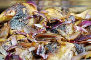 Chicken thighs with sauteed onions in pan