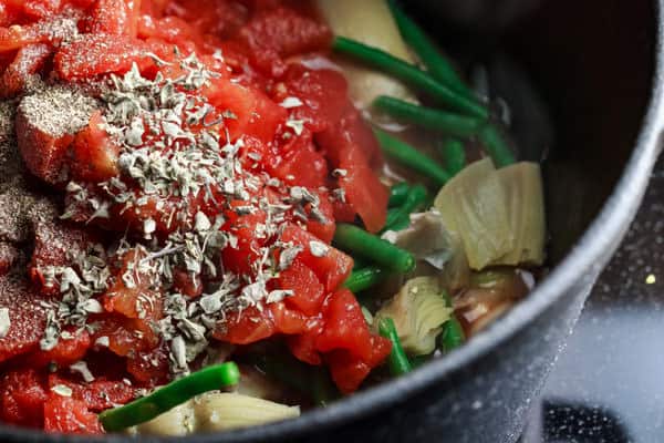 Onion, celery, garlic, green beans, artichoke hearts, canned tomatoes, dried oregano and a small dash of salt and pepper in a pan