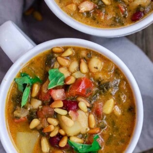 Mediterranean Bean Soup with Tomato Pesto | The Mediterranean Dish. Tons of flavor in this cozy bean soup loaded with vegetables, and Mediterranean flavors from spices and amazing fresh tomato pesto. This is not your average bean soup! A must try from TheMediterraneanDish.com #beansoup #mediterraneandiet #mediterraneanfood #mediterraneanrecipes #vegetablesoup #vegetarian #glutenfree #budgetfriendly #onepot #chickpeas #kidneybeans #beans #soup