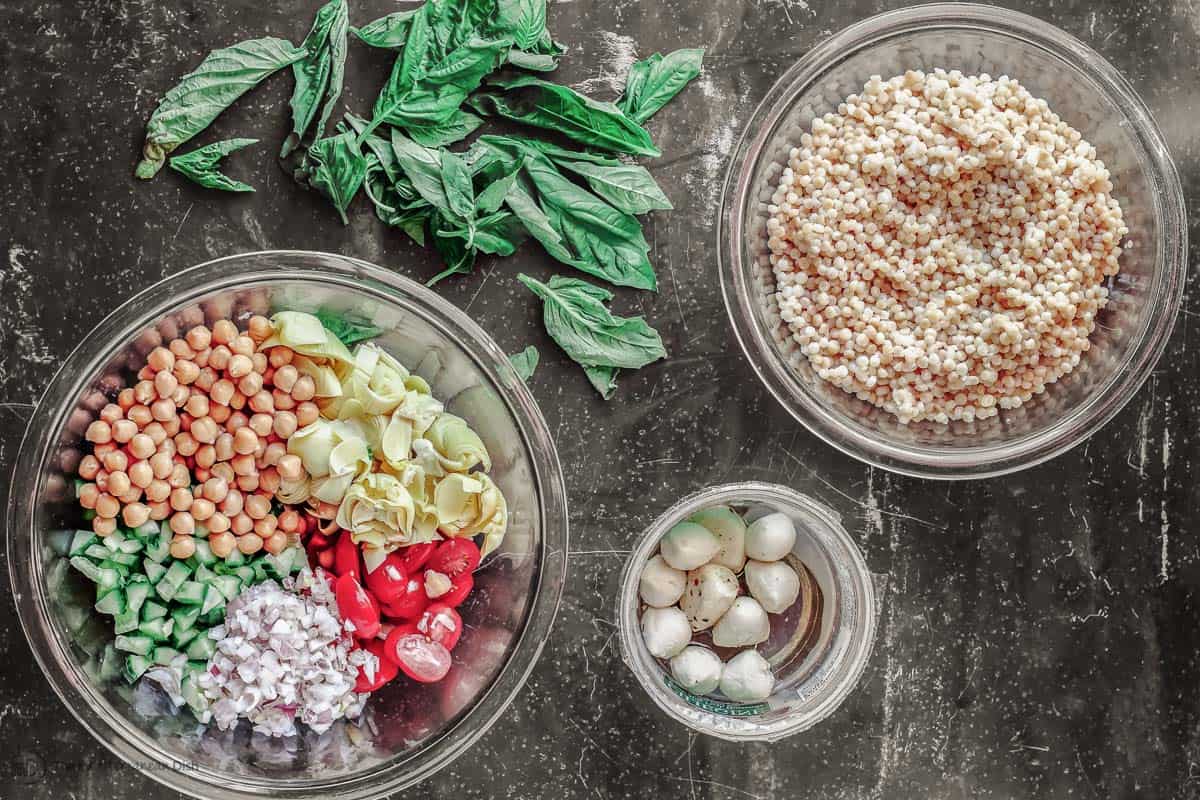 Ingredients for pearl couscous salad in separate bowls