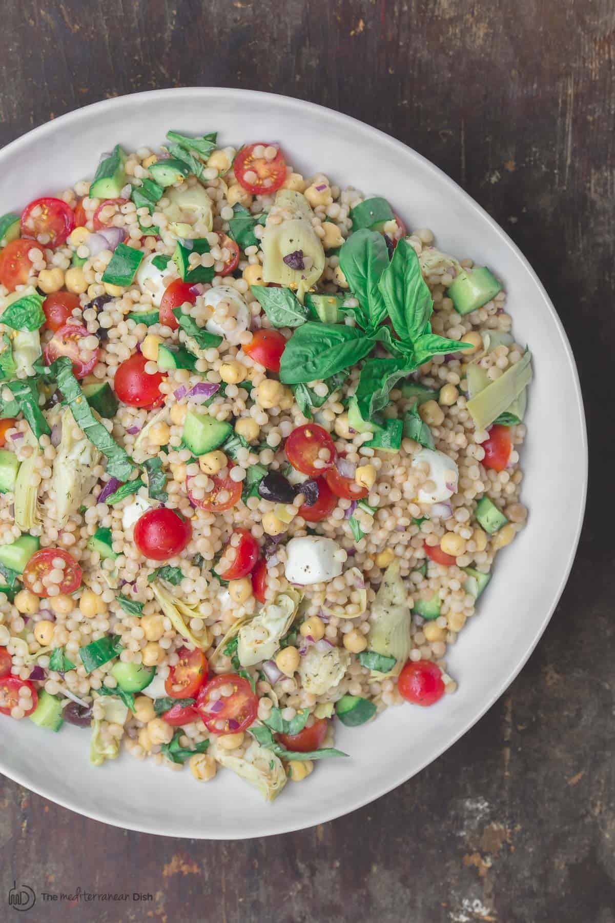 Mediterranean pearl couscous salad served in large bowl