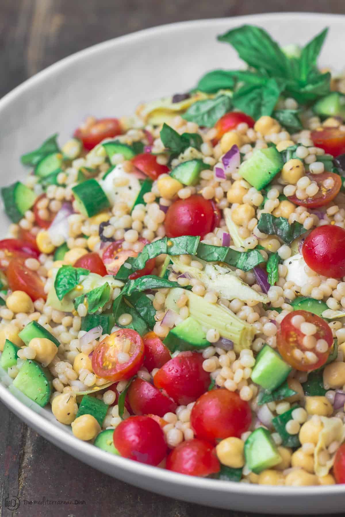 Mediterranean pearl couscous salad served in large bowl