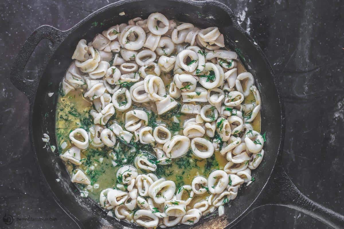 Lime juice, spices and dill are added to calamari skillet