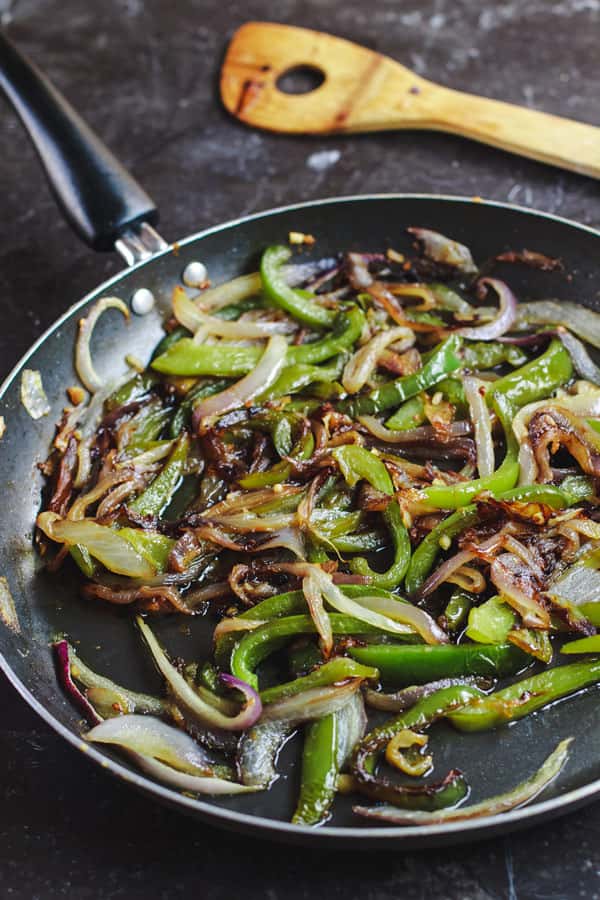 Saute peppers and onions in a pan