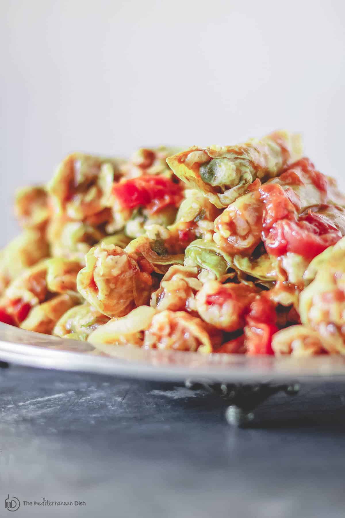 Vegetarian stuffed cabbage rolls piled on top of a plate