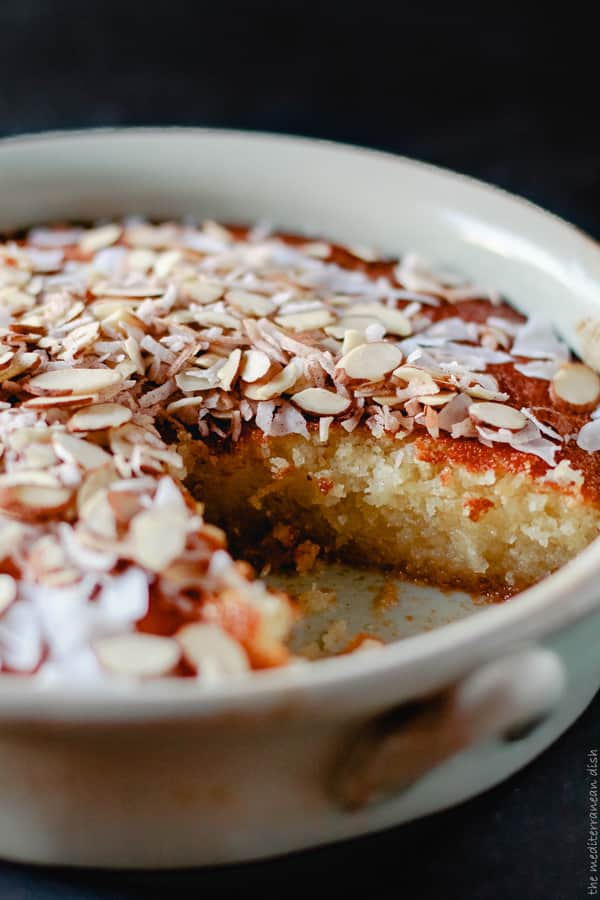 Basbousa cake in a serving dish with one slice removed