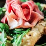 Easy puff pastry topped with grilled pears, prosciutto and goat cheese from The Mediterranean Dish. Get this all-star recipe today! It will win your guests heart at the first bite!