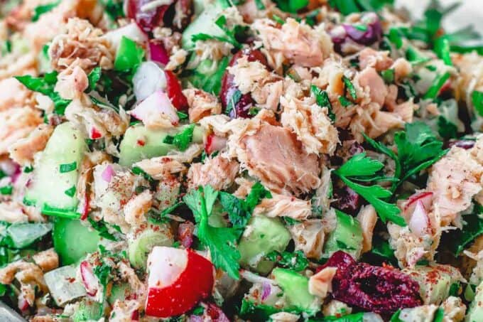 Mediterranean Tuna Salad with fresh herbs, chopped vegetables and Dijon vinaigrette on a plate