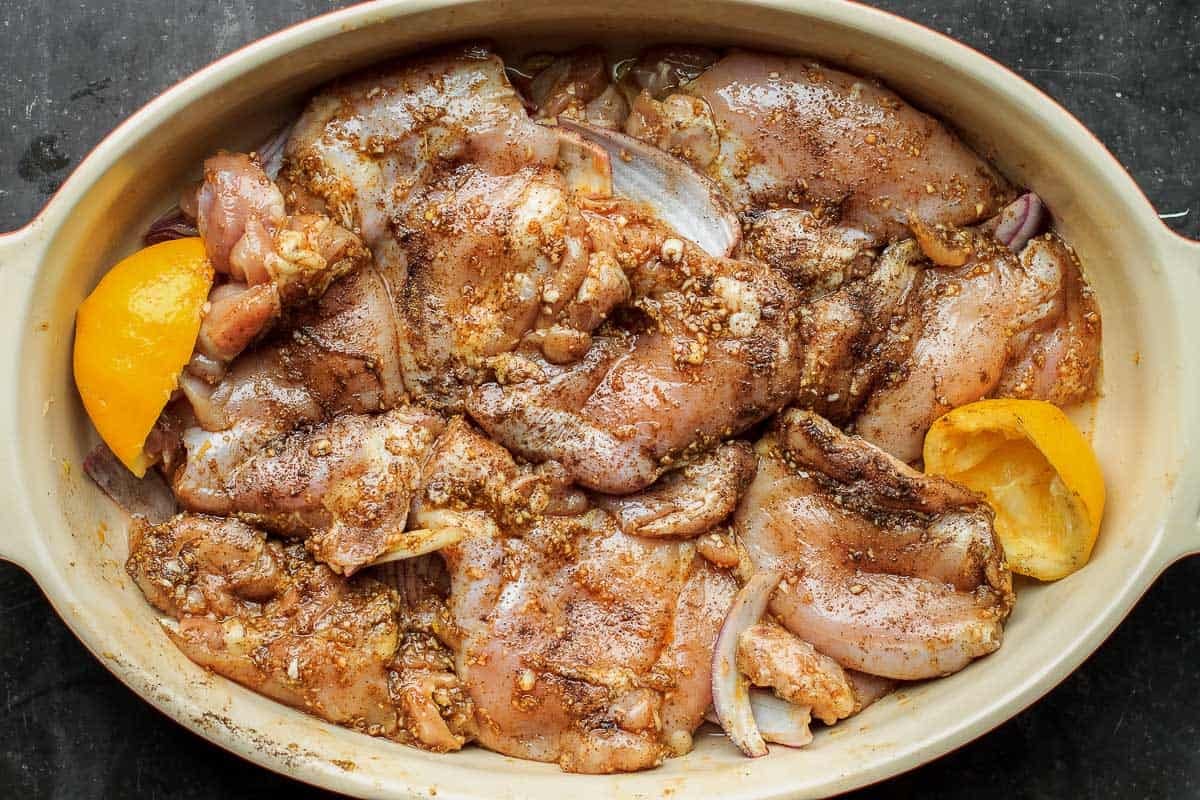 chicken thighs marinating in garlic, spices, olive oil 