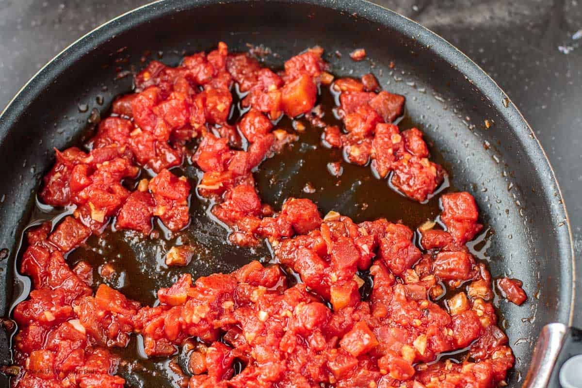 Canned tomatoes cooking in skillet