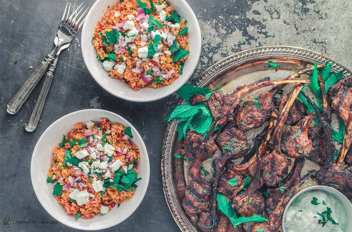 Grilled Lamb chops on platter with Tztaziki. Quinoa bowls to the side