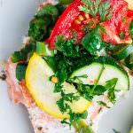 Mediterranean-style Oven Baked Salmon in Foil | The Mediterranean Dish. Salmon with garlic and thyme, topped with vegetables and a buttery-lime sauce and baked in foil to perfection! Bakes in less than 25 mins! Try this easy dinner soon.