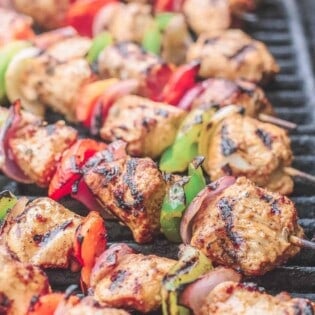 Chicken kabobs arranged on an open-flamed grill
