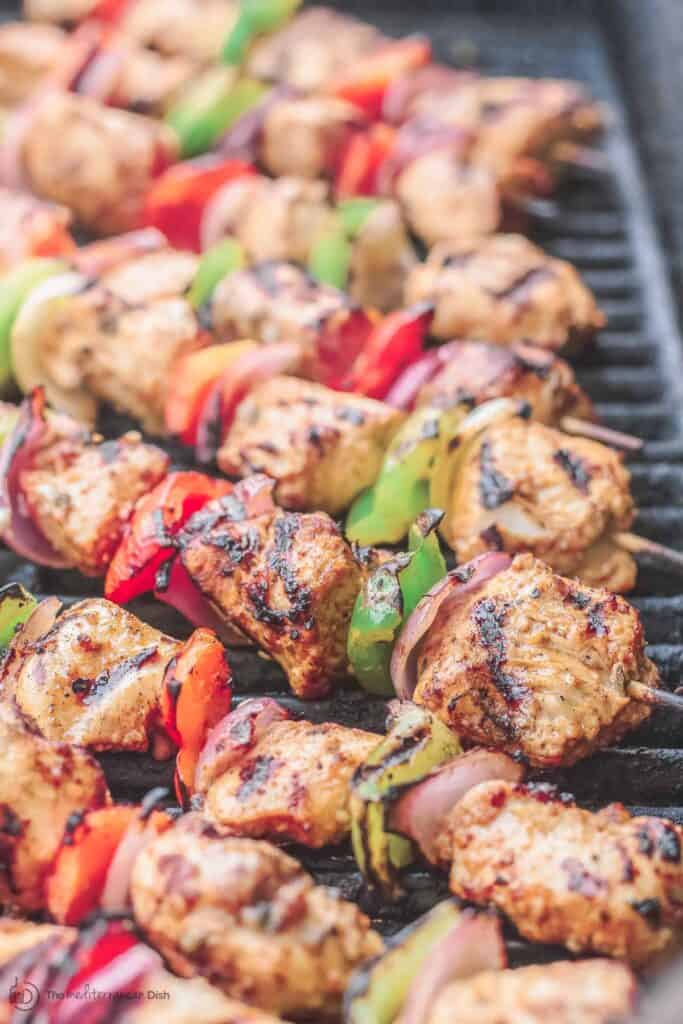 Chicken kabobs arranged on an open-flamed grill
