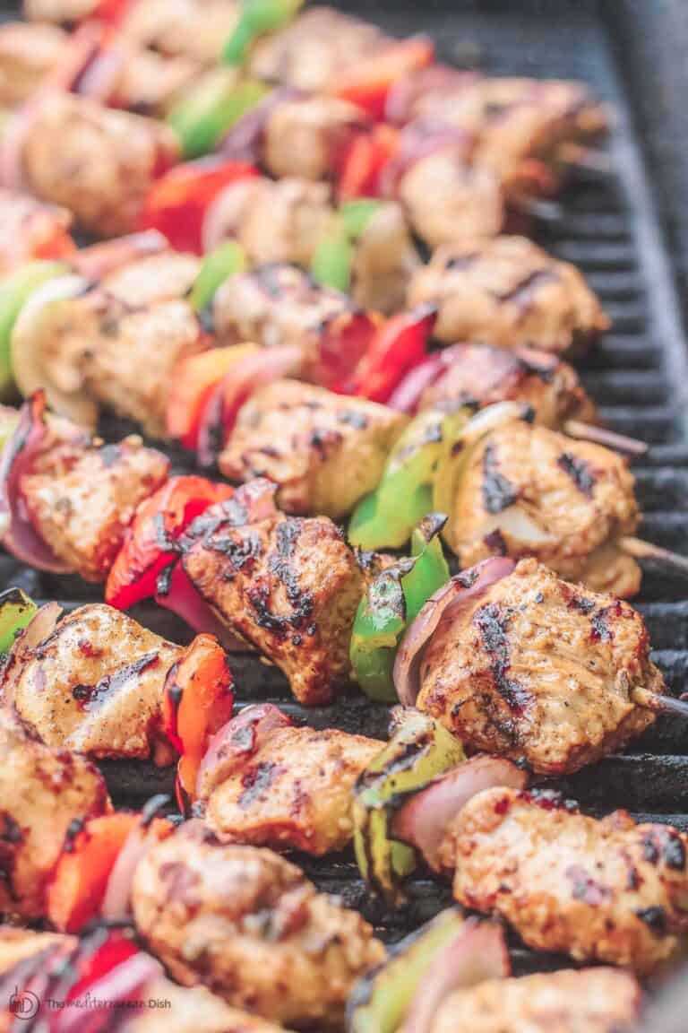 Chicken kabobs arranged on an open-flamed grill