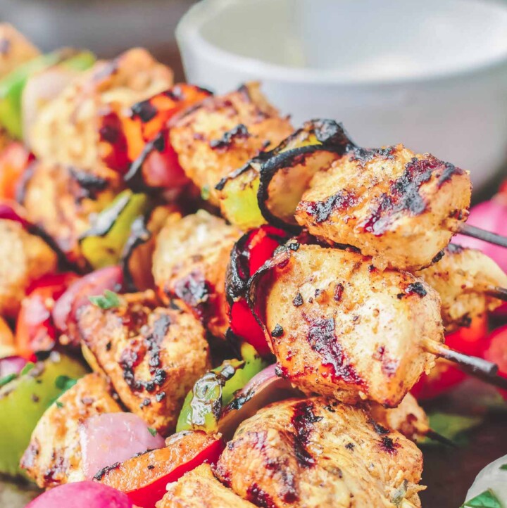 Grilled chicken kabob stacked on top of each other on a serving dish