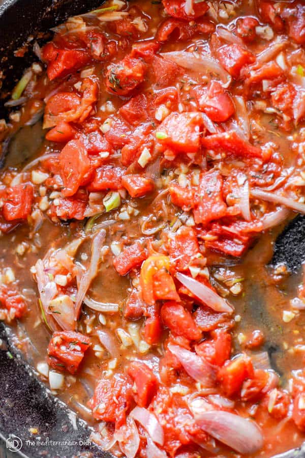 Tomato sauce with spices combined and cooking in a skillet