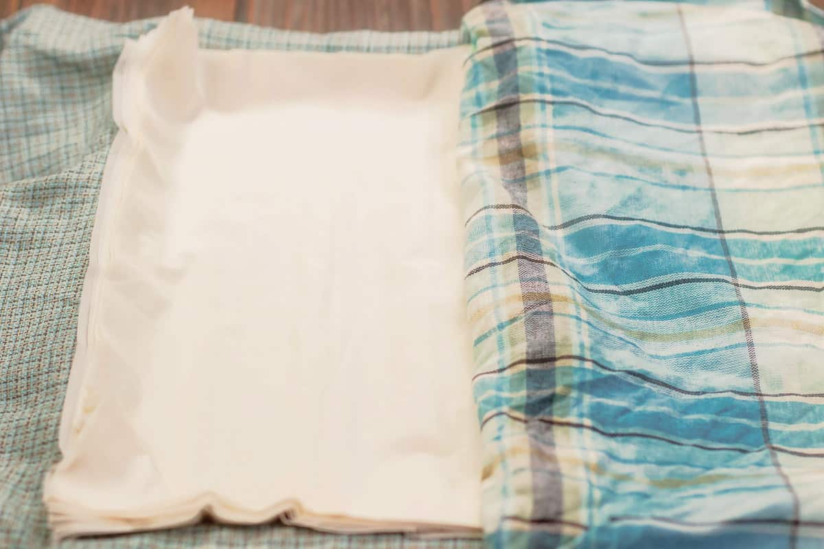 phyllo dough with a blue dish towel next to it to cover it.