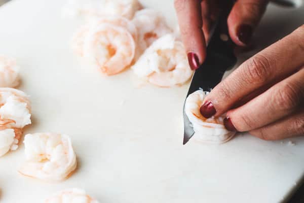 Shrimp being cut in half length-wise