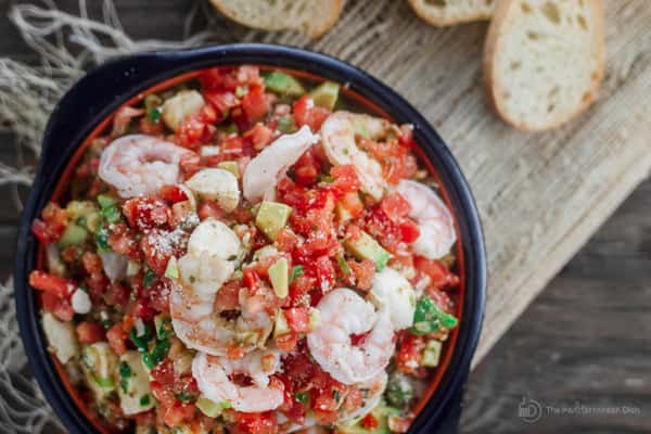 Bowl of combined ingredients for Shrimp Bruschetta with bread on the side