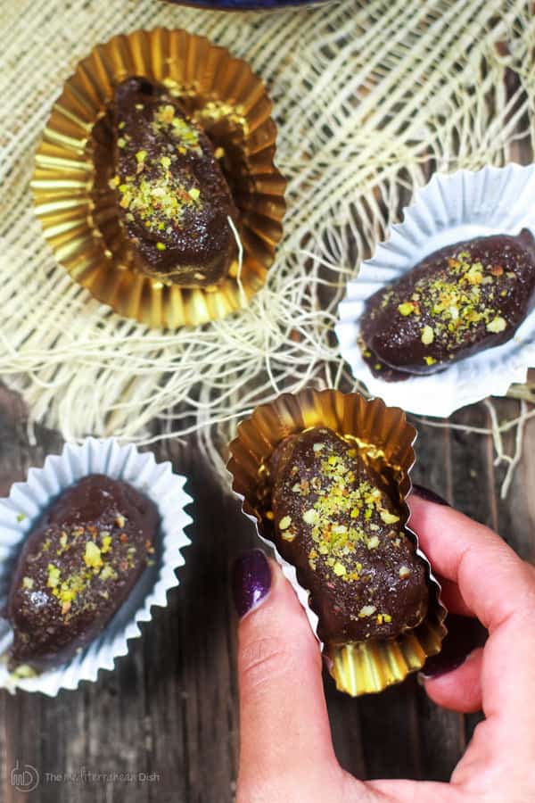 Close-up of individually wrapped dates covered in chocolate and nuts