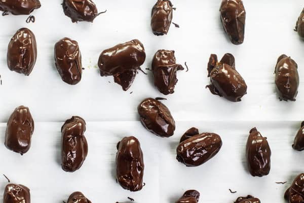 Chocolate Covered Dates placed on parchment paper to dry