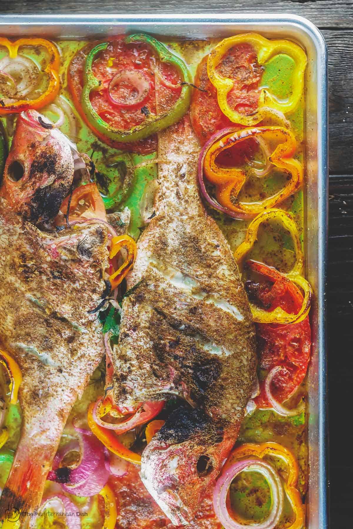 2 Whole red snapper with vegetables roasted in a large sheet pan