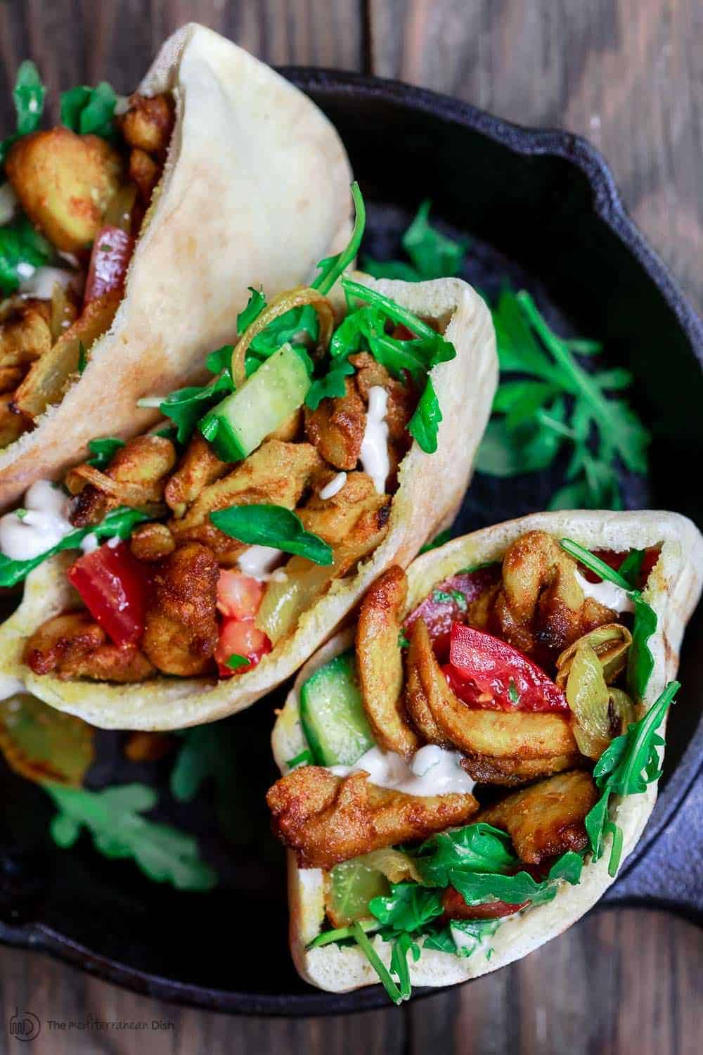 Homemade baked chicken shawarma in pita pockets with salad and greens 