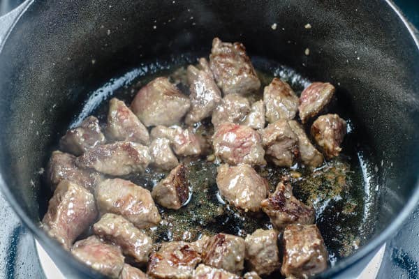 Chunks of beef cooking in a large pot
