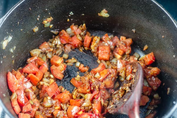 Pot with chopped onion, garlic, tomatoes and tomato paste, allspice, paprika, cinnamon, coriander, a dash of salt and pepper. 