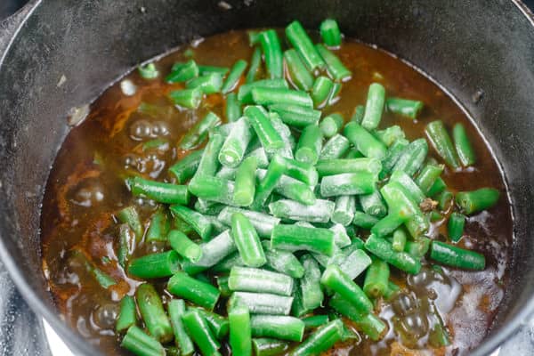 Frozen green beans added to the pot of beef and spices.