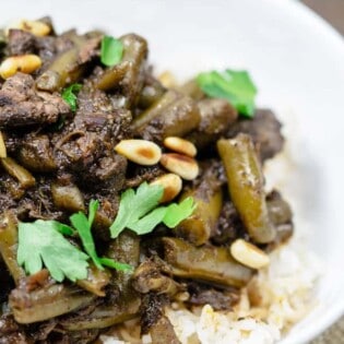 Middle Eastern Beef Stew Recipe with Green Beans | The Mediterranean Dish. Tender beef stew cooked with green beans and tomatoes with warm spices like coriander, cinnamon and allspice. Step-by-step photos included with the recipe. Click the pin to follow!