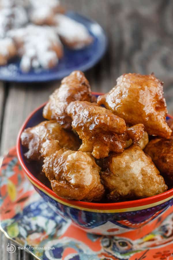 Two servings of donuts, one covered in cinnamon syrup and other in powdered sugar