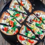 15-minute Artichoke Garden Flatbread Pizza | The Mediterranean Dish. Mediterranean-style flatbread pizza with artichokes, tomatoes, olives, feta and more! With ready low-carb, high fiber Flatout® Flatbread!