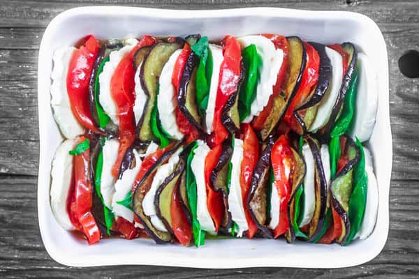 Baking dish completely filled with Caprese salad ingredients ready to be baked