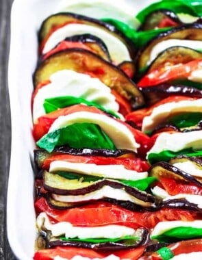 Roasted Eggplant Caprese Salad Recipe | The Mediterranean Dish. A satisfying appetizer or even side dish! Roasted eggplants, tomatoes, and melted mozzeralla cheese with basil nestled in between. Dressed in a simple basil viniagrette! See the step-by-step tutorial on The Mediterranean Dish