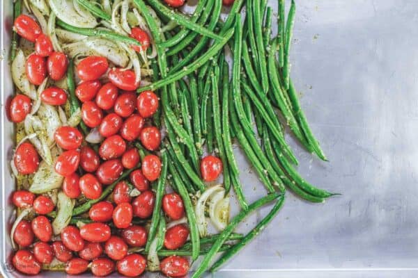 Green beans, cherry tomatoes, and onions added to sheet pan